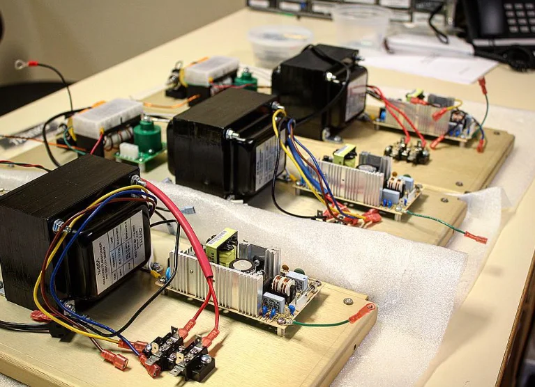 Three 858 power supply assemblies on wooden boards, each with a transformer, a switching supply and wiring