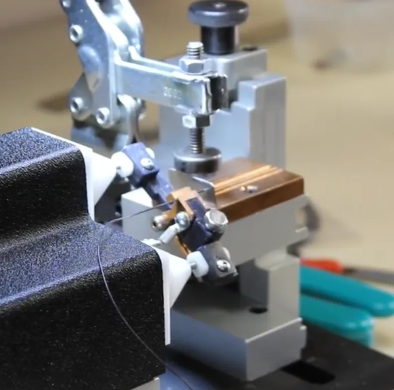 Fine wire positioned in the wire holder of the 726 bench fixture next to the copper block and clamp