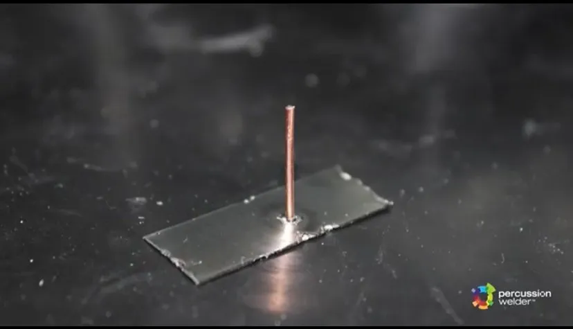 Single copper wire standing upright on a flat metal strip after welding