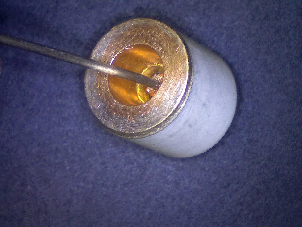Close-up of a ceramic tube end with a small tool tip inside, magnified