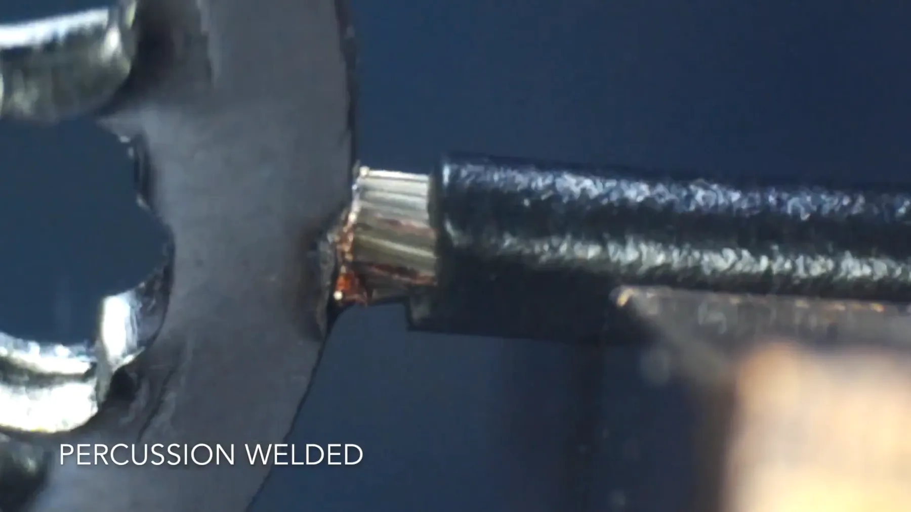 Welded cable end held in a clamp, captioned Percussion Welded