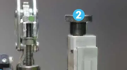 Close-up of a fixture clamp and electrode block with a numbered callout 2